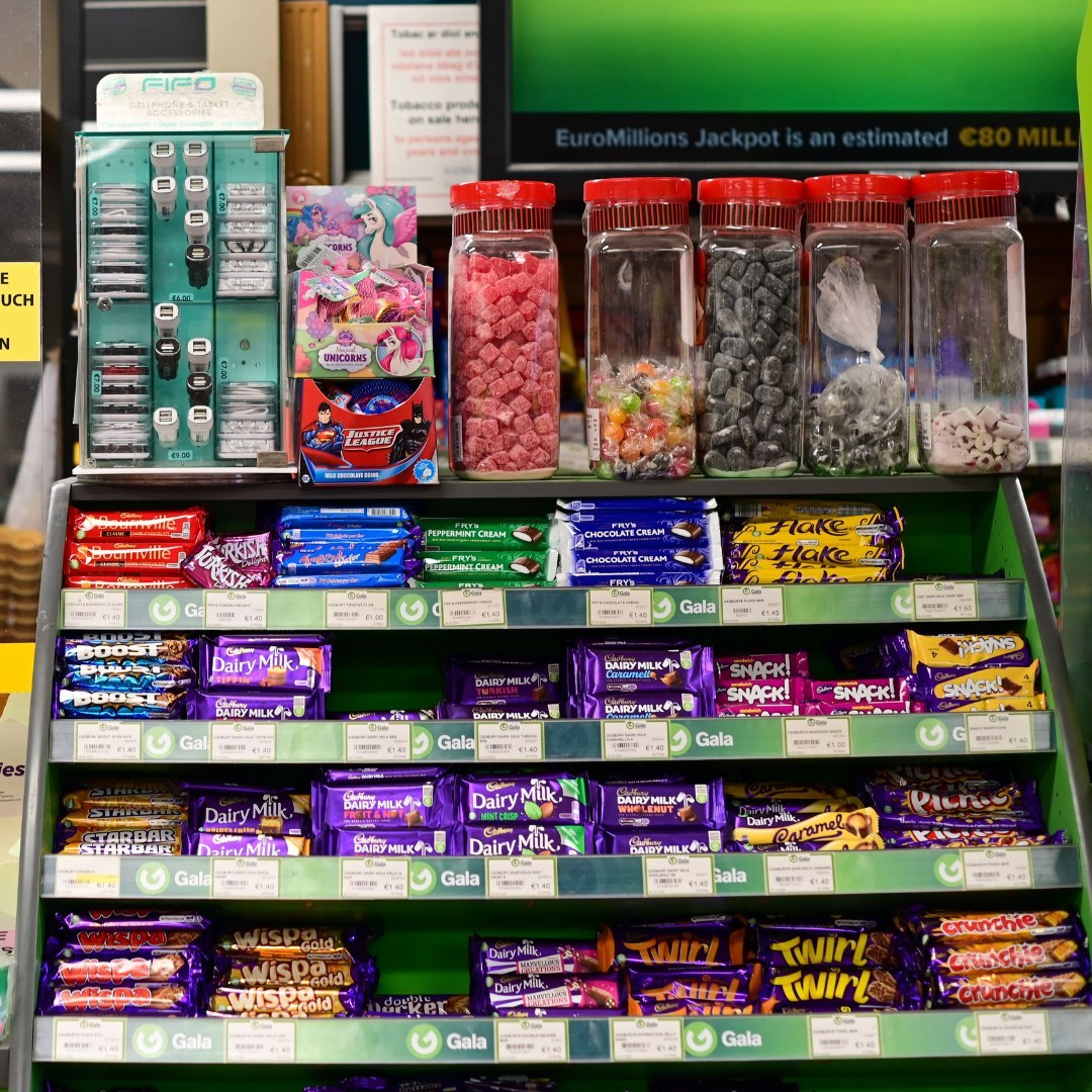 In store confectionery aisle with chocolate bars on Gala shelves and jars of loose sweets above